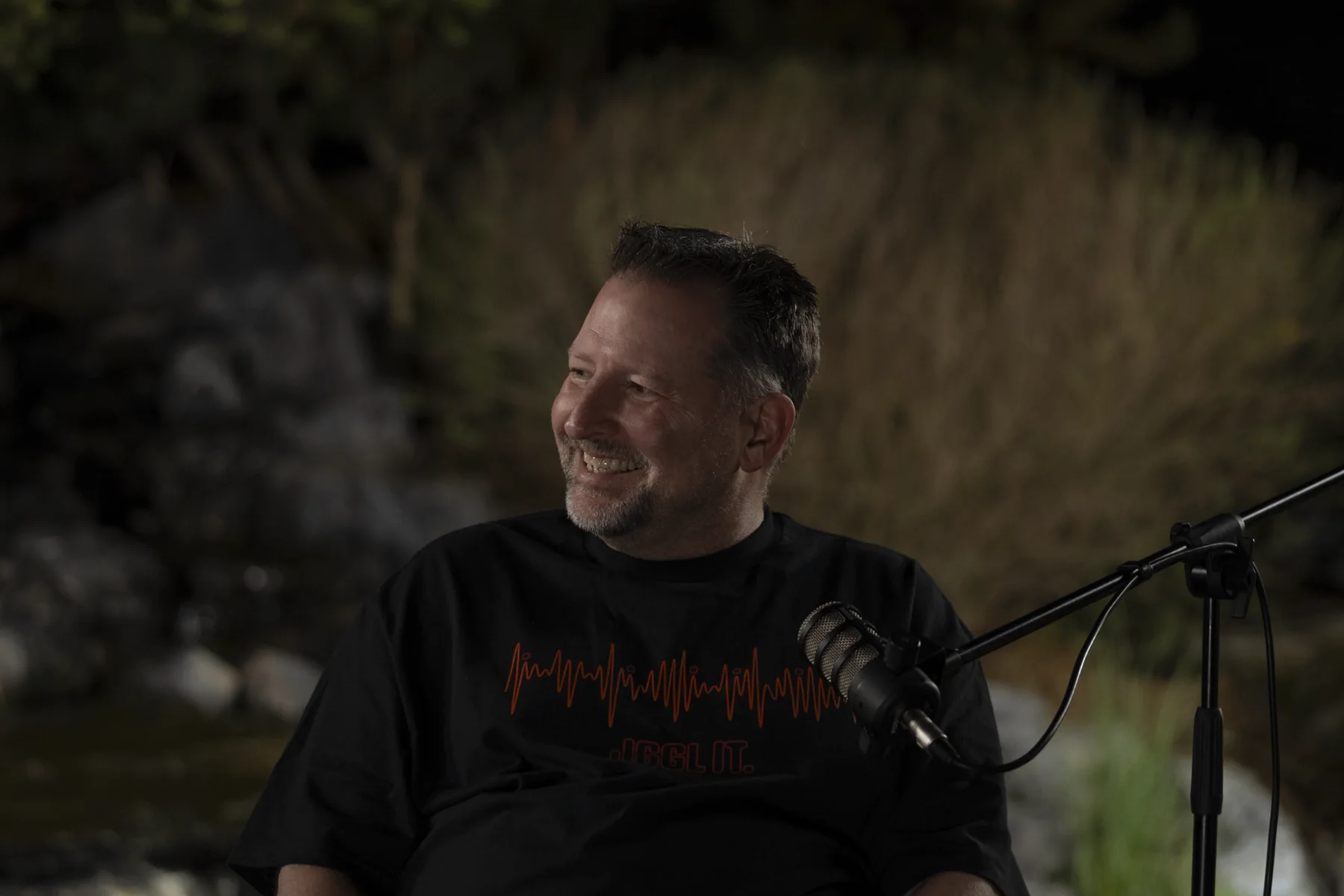 Brad Barton laughing during an outdoor conversation at night