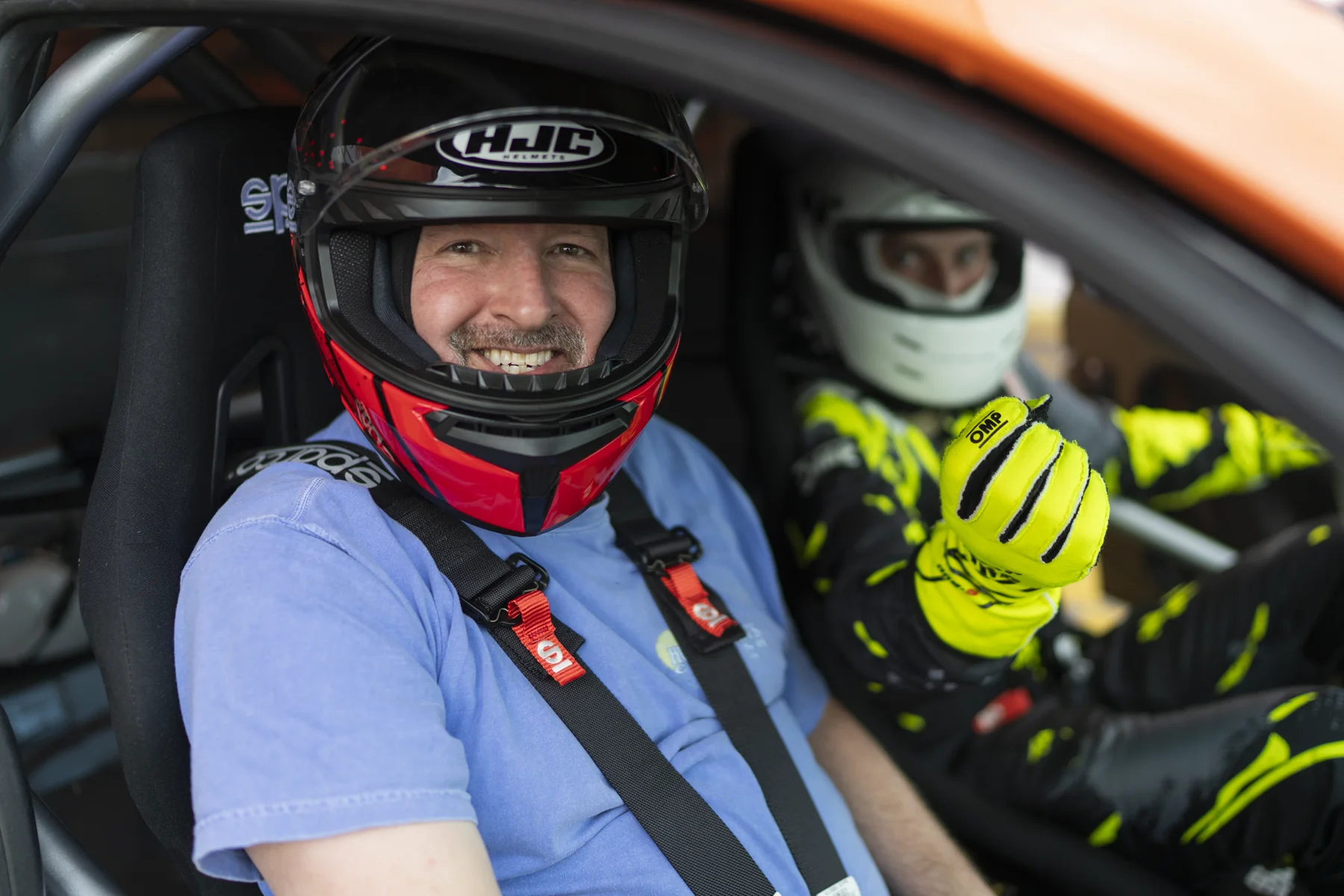 Brad Barton smiling in a racing helmet inside a car